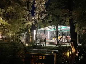 Exterior night view of Hikari no Hako, a fully glass-walled villa nestled in the forest at COMOREBI Yufuin glamping resort.