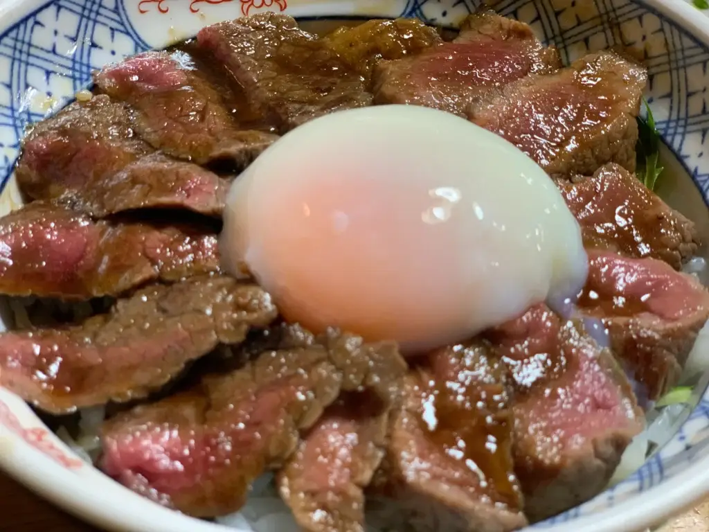 The famous Akaushi-don (red beef bowl) from Imakin Shokudo in Aso, featuring perfectly cooked medium-rare wagyu beef.