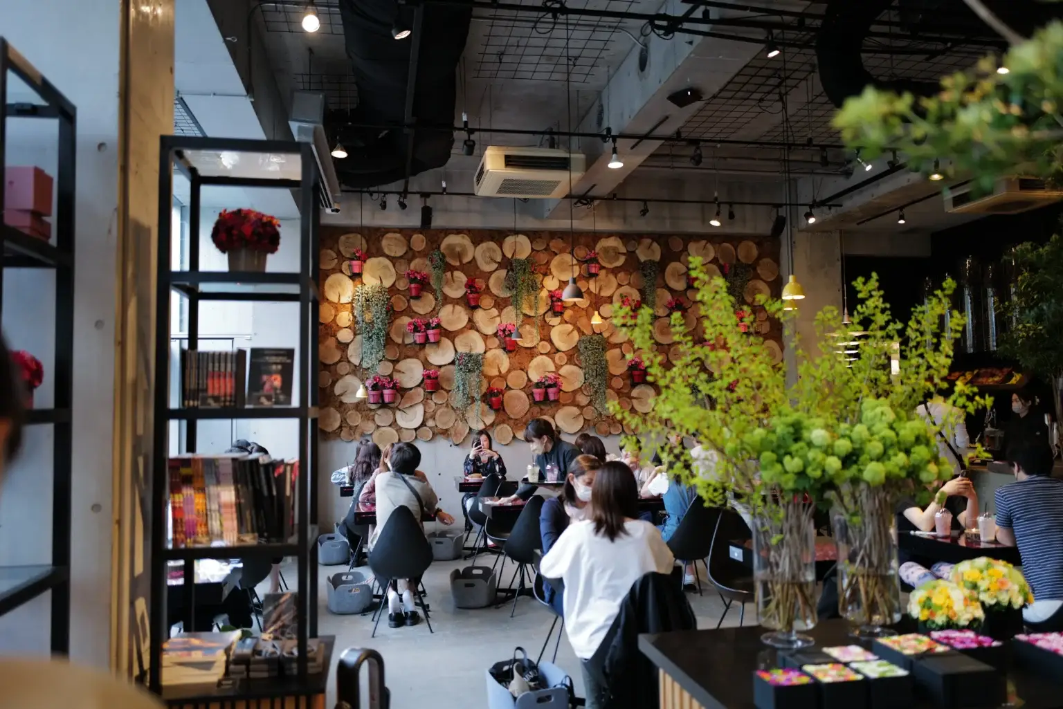 The cozy and stylish seating area inside the NOMU cafe, featuring a stunning wall decorated with natural wood slices.