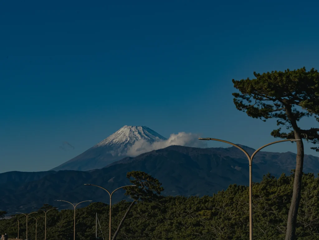 The snow-dusted summit of Mt. Fuji glowing in the morning sun, highlighting the severe beauty of climbing Mt Fuji in winter.