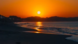 Sunrise over Shichirigahama Beach in Kamakura, with golden light reflecting on the sea and the silhouette of Enoshima