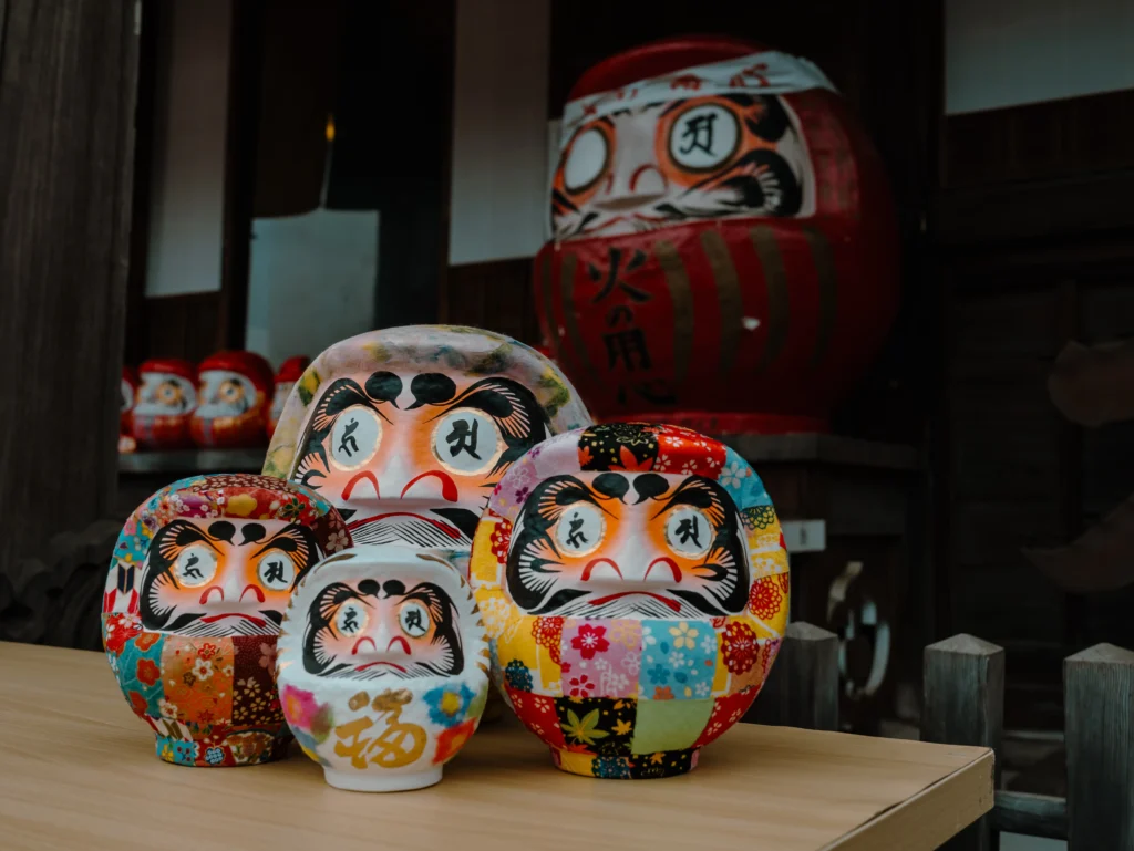 Hundreds of red and white daruma dolls are piled high on a stall at the Jindaiji Daruma Ichi.