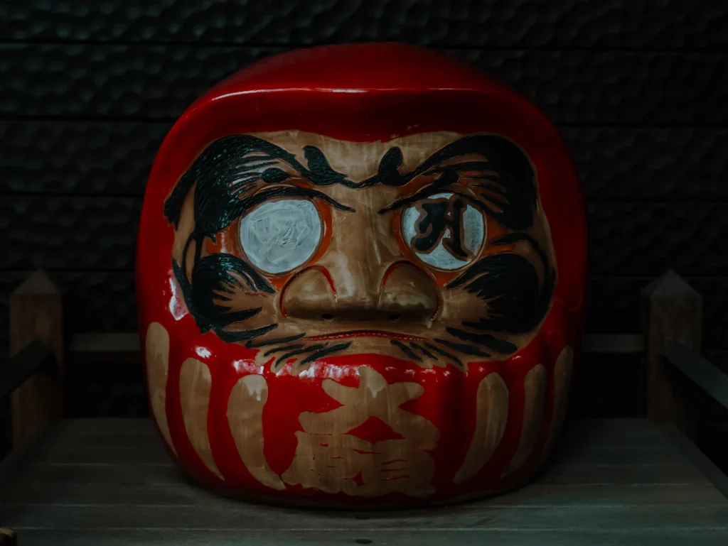 A close-up of a large daruma doll's eye with the special Sanskrit character "A" painted by a monk at the Jindaiji Daruma Ichi.