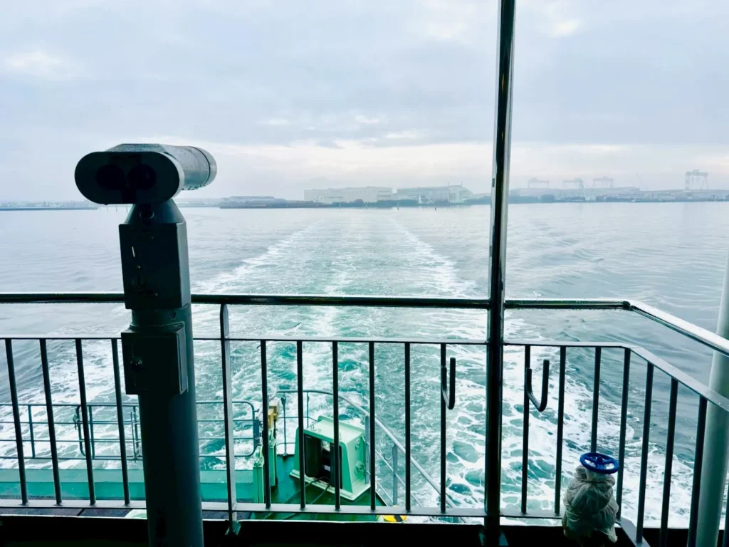Wake view from the Ariake Ferry deck with a coin-operated binocular overlooking calm Ariake Sea waters