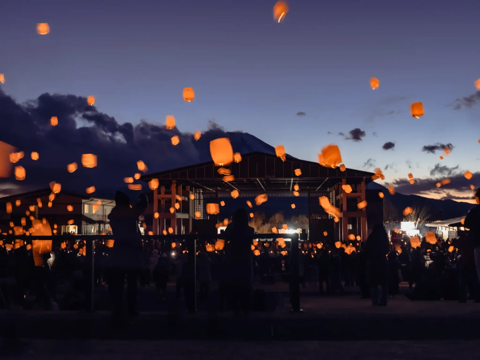 Lanterns rising over Koryu Plaza Kirara at dusk during the Lake Yamanakako Ice Candle Festival.