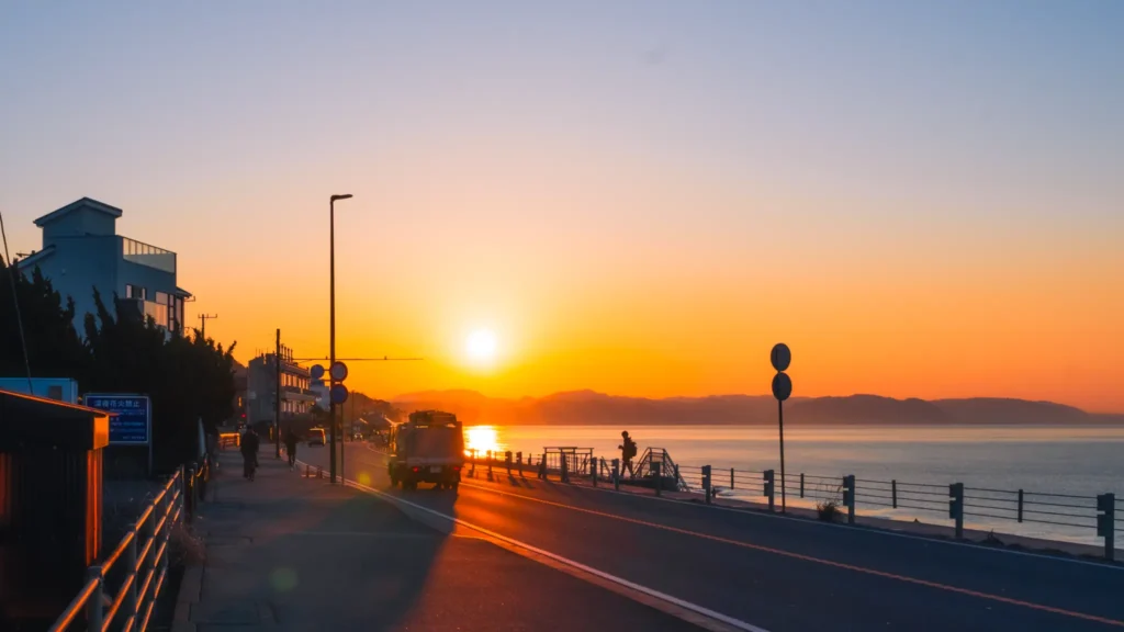 The sun rising over the hills, casting golden light on Route 134 along the Shichirigahama coast.