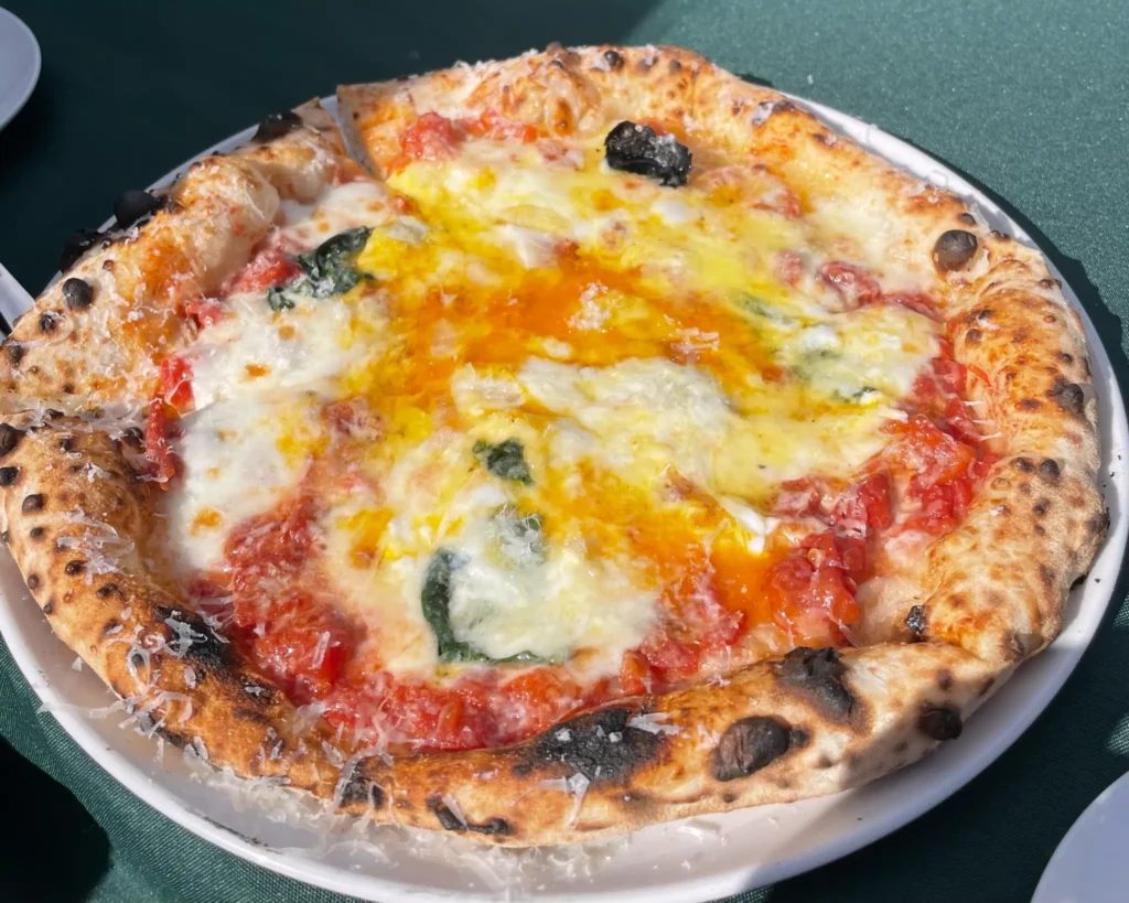 A freshly baked Margherita pizza from Pizzeria Tre Passo, with a perfectly charred crust and melted mozzarella.