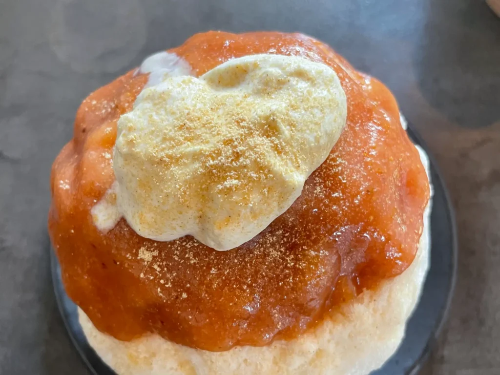 Close-up of the Hakata Pure Ice texture and peach-chai topping at Omame Yoshiko Kakigori Fukuoka.