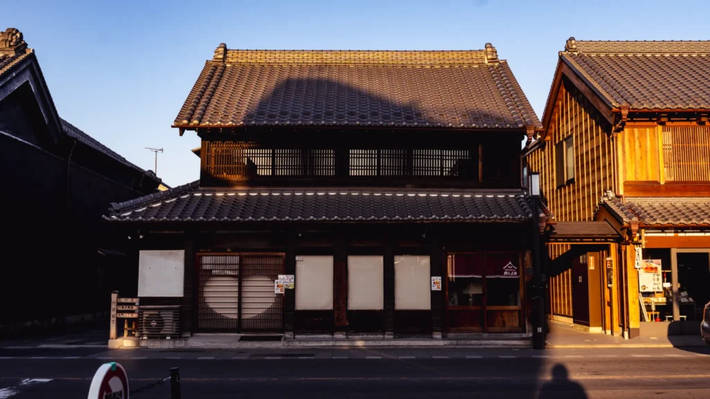 A Kurazukuri merchant house in Kawagoe with traditional lattice windows and a sweet potato shop, showcasing the architectural details of the warehouse district.