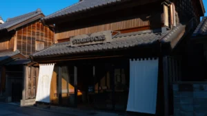 The exterior of the Starbucks Kawagoe Kanetsuki-dori store, showing its traditional wooden design and noren curtain.