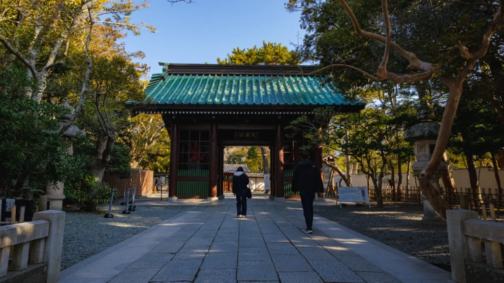 The Niomon Gate, the entrance to Kotoku-in Temple, with visitors walking towards it.