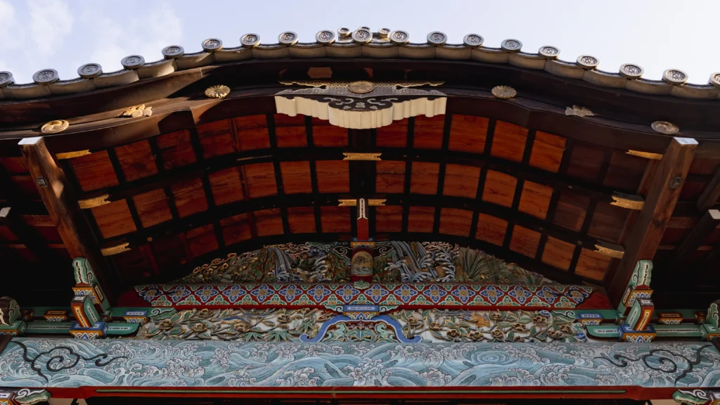 A close-up of the vibrant, masterfully restored carvings on the Worship Hall, a hallmark of Momoyama-period artistry.