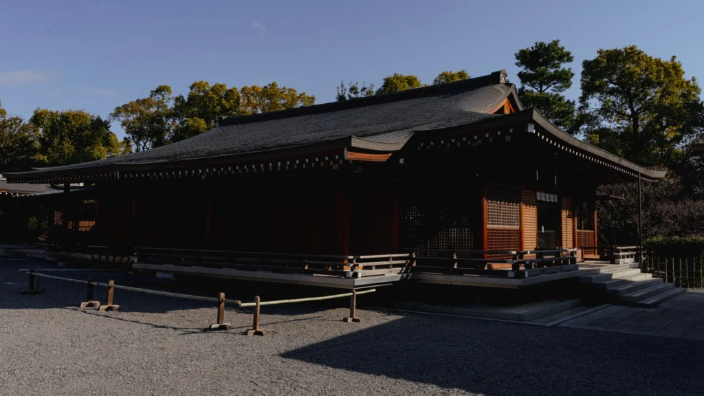 A wide view of Jonangu Shrine's precincts showing the Butaiden stage hall and surrounding traditional wooden buildings under a clear sky.