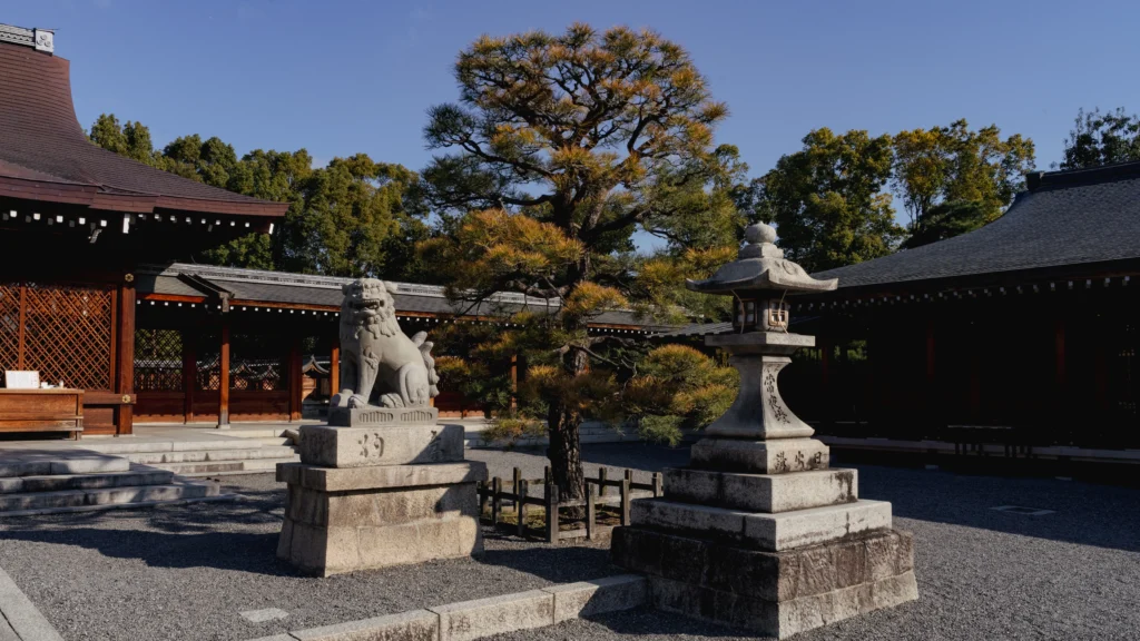 The Haiden (Hall of Worship) at Jonangu Shrine, featuring a grand shimenawa rope and stone komainu guardian lion-dogs flanking the entrance.