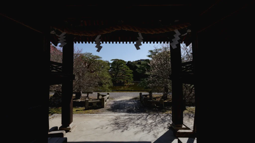 A view through the shrine gate toward the tranquil garden beyond.