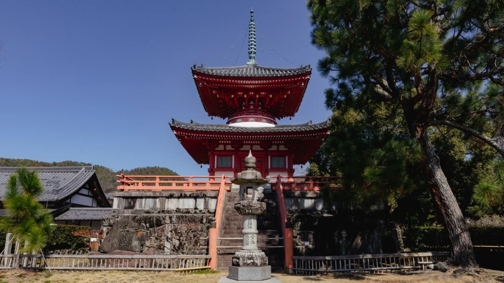 The striking vermilion Shingyo Pagoda standing by the edge of Osawa Pond.