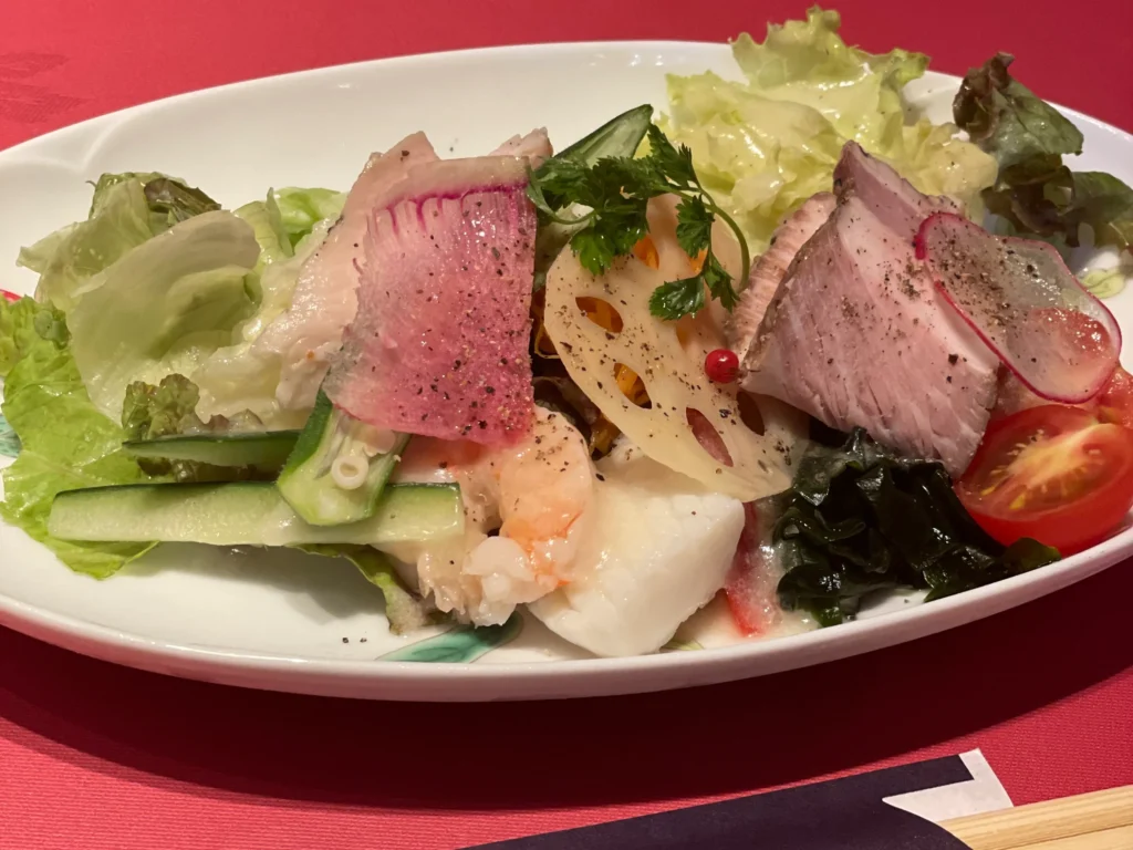 The elaborate salad set at Shirayamasha, featuring shrimp, roasted pork, lotus root, and fresh vegetables