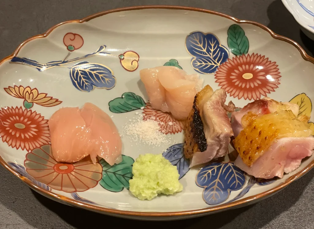 A beautifully arranged platter of fresh chicken sashimi served on a traditional Japanese plate at Yakitori Mamori