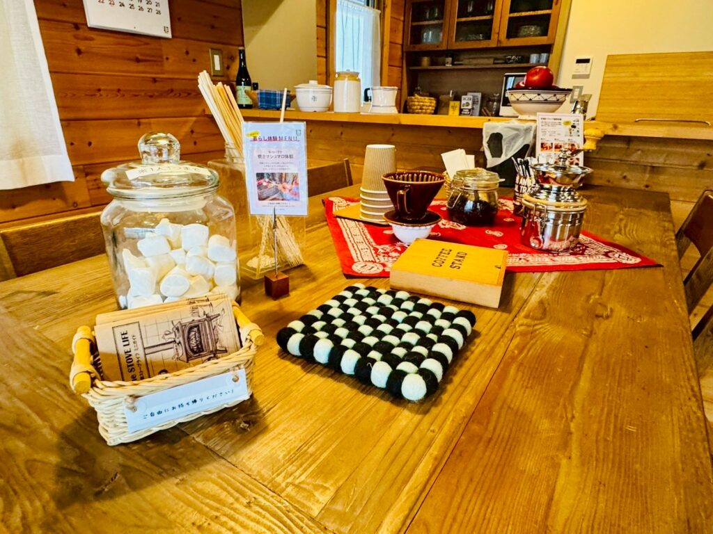 A striking A-frame log house model at BESS Kumamoto, showcasing the classic triangular roof design surrounded by greenery.
