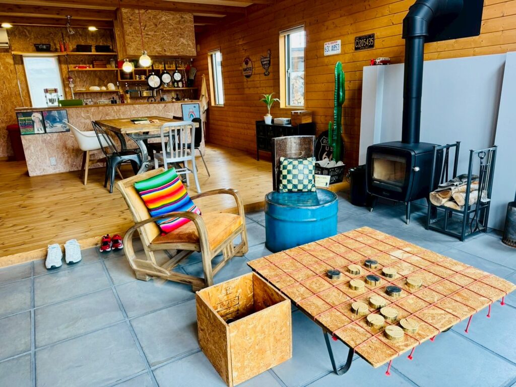 A traditional grey log house at BESS Kumamoto, built with authentic stacked log construction.