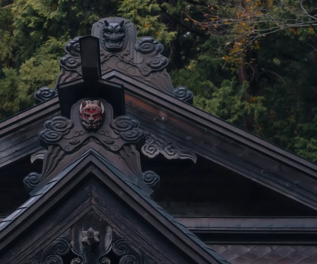 Intricate Onigawara (ogre tile) on the roof of the shrine building.