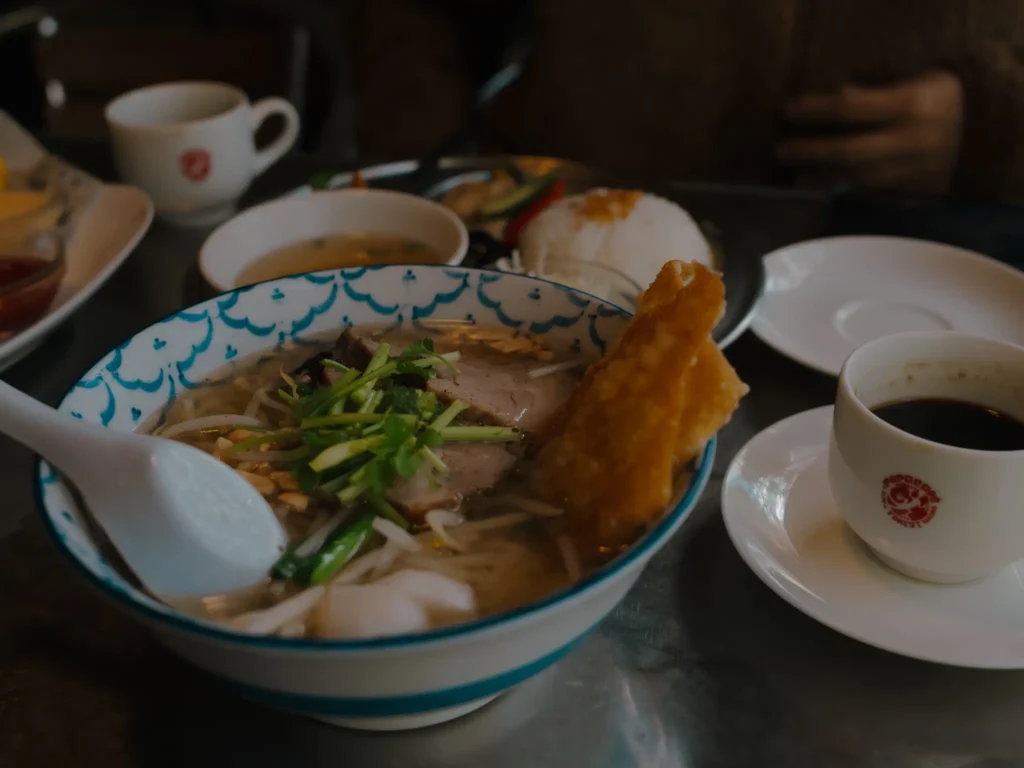 A bowl of Vietnamese pho and a cup of coffee on a table at Pepacafe Forest.