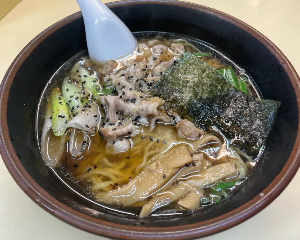 A close-up of the Tokusei Juhachiban, showing the signature hand-kneaded noodles and toppings.