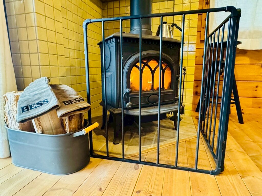 A log splitting station at BESS Kumamoto, with an axe and splitting tools set up on a tree stump ready for visitors to try.