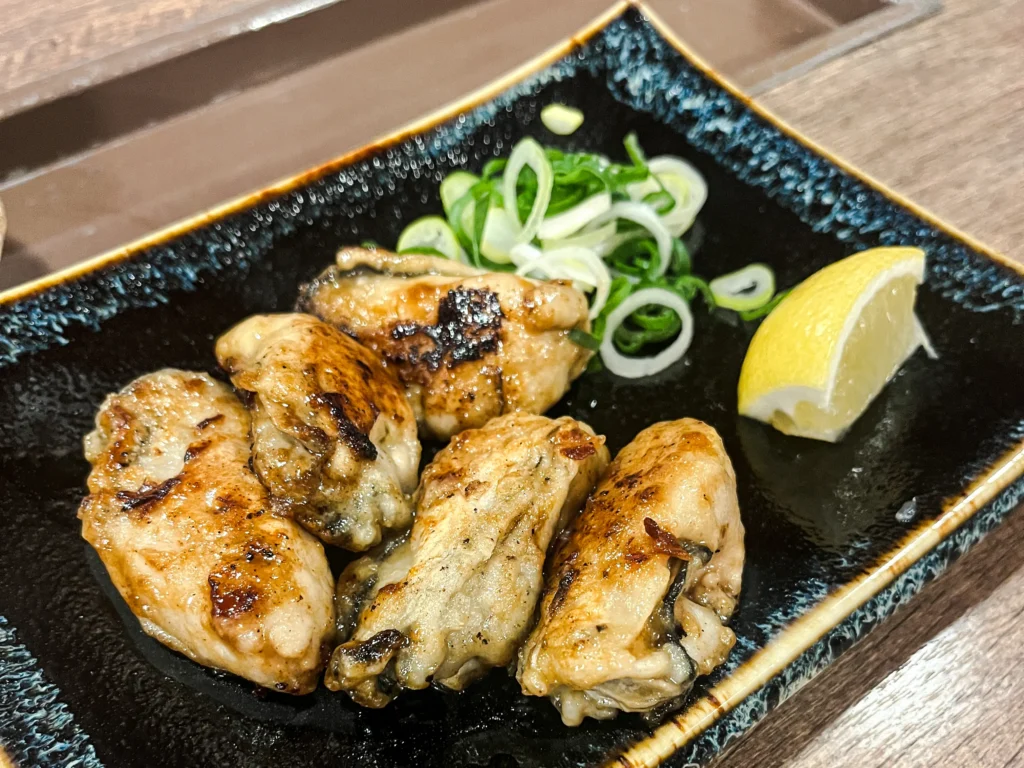 Teppan-grilled Hiroshima oysters with sliced green onions and lemon at Mitchan Souhonten