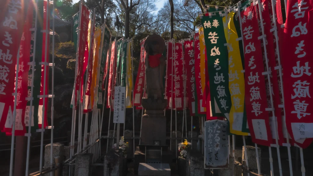 Kuninuki Jizo statue surrounded by colorful devotional banners at Kitain Temple