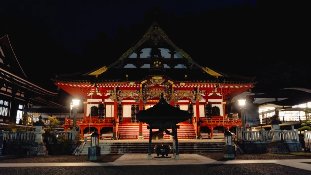 The vermilion Soshido hall at Kuonji at night with incense burner in the foreground