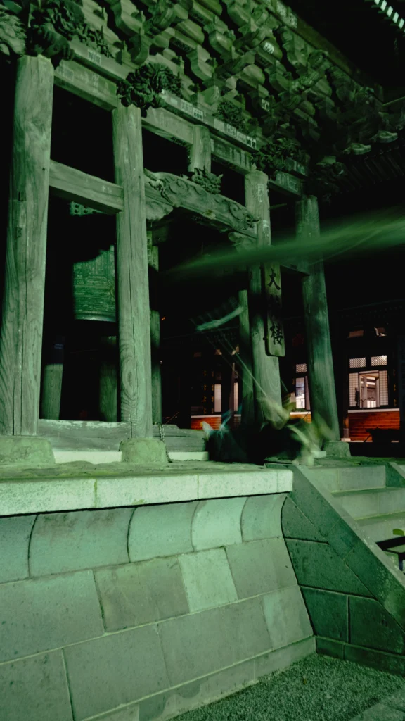 A monk at Kuonji Temple leaning his entire body backward to swing a massive wooden beam into the Great Bell