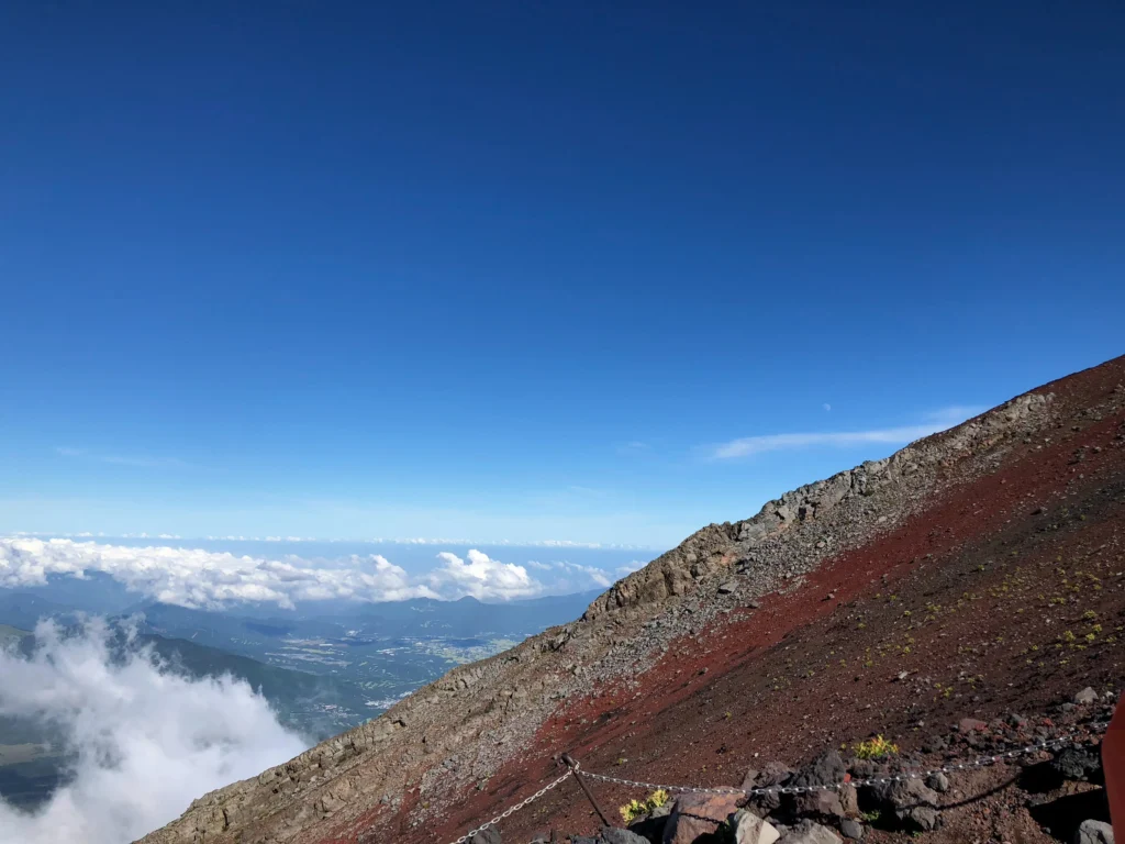 The red scoria descent route on Mt. Fuji's Yoshida trail with clouds below