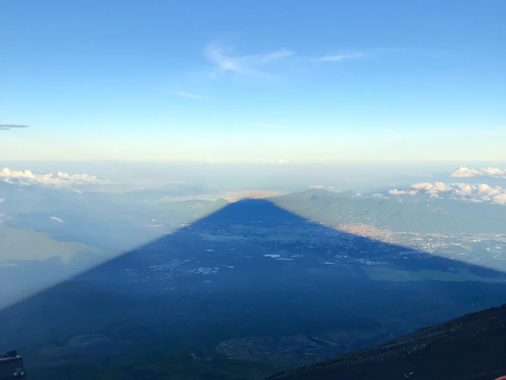 The perfect triangular shadow of Mt. Fuji cast across the landscape below