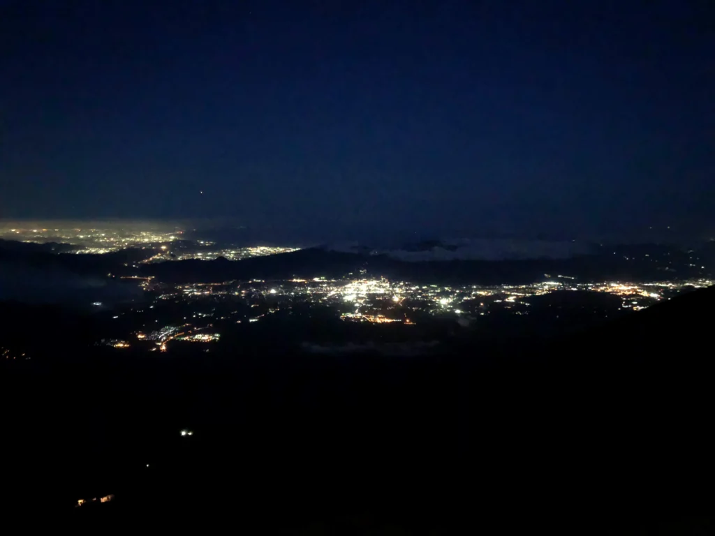 City lights of the Fuji Five Lakes area glowing below the mountain