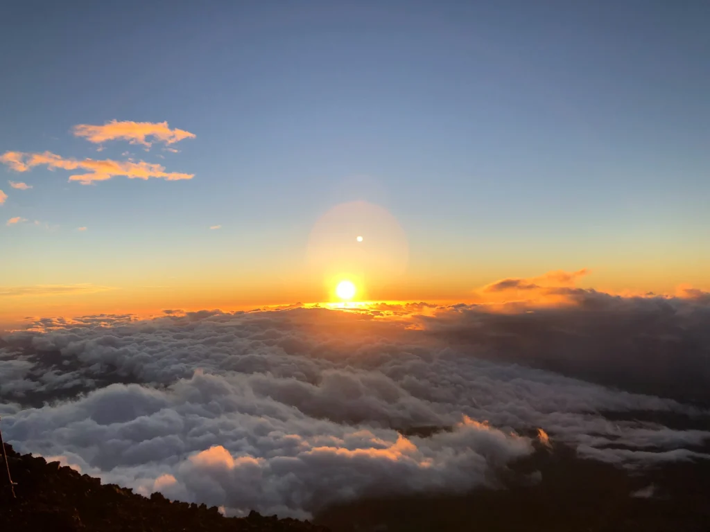 The sun emerging from the cloud sea, golden rays radiating outward