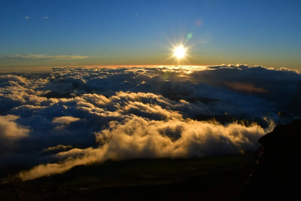 Sun with starburst rays above the cloud sea