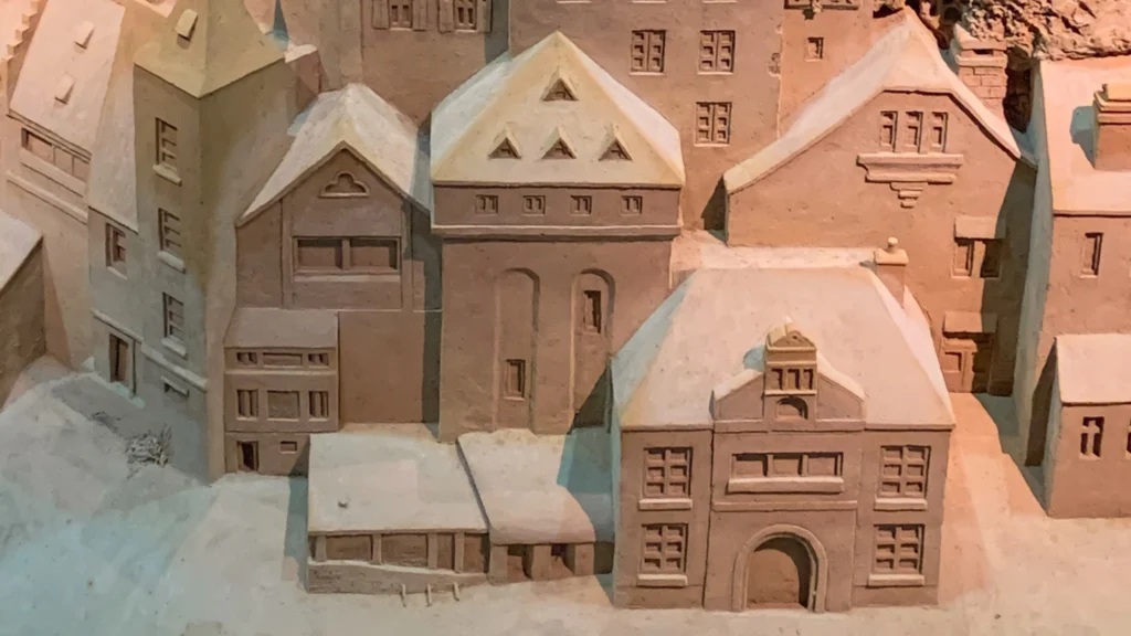 Close-up of a meticulously detailed miniature European village carved entirely from sand