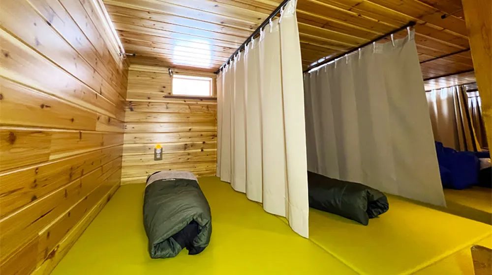 Semi-private sleeping space with curtain dividers in Mt. Fuji mountain hut