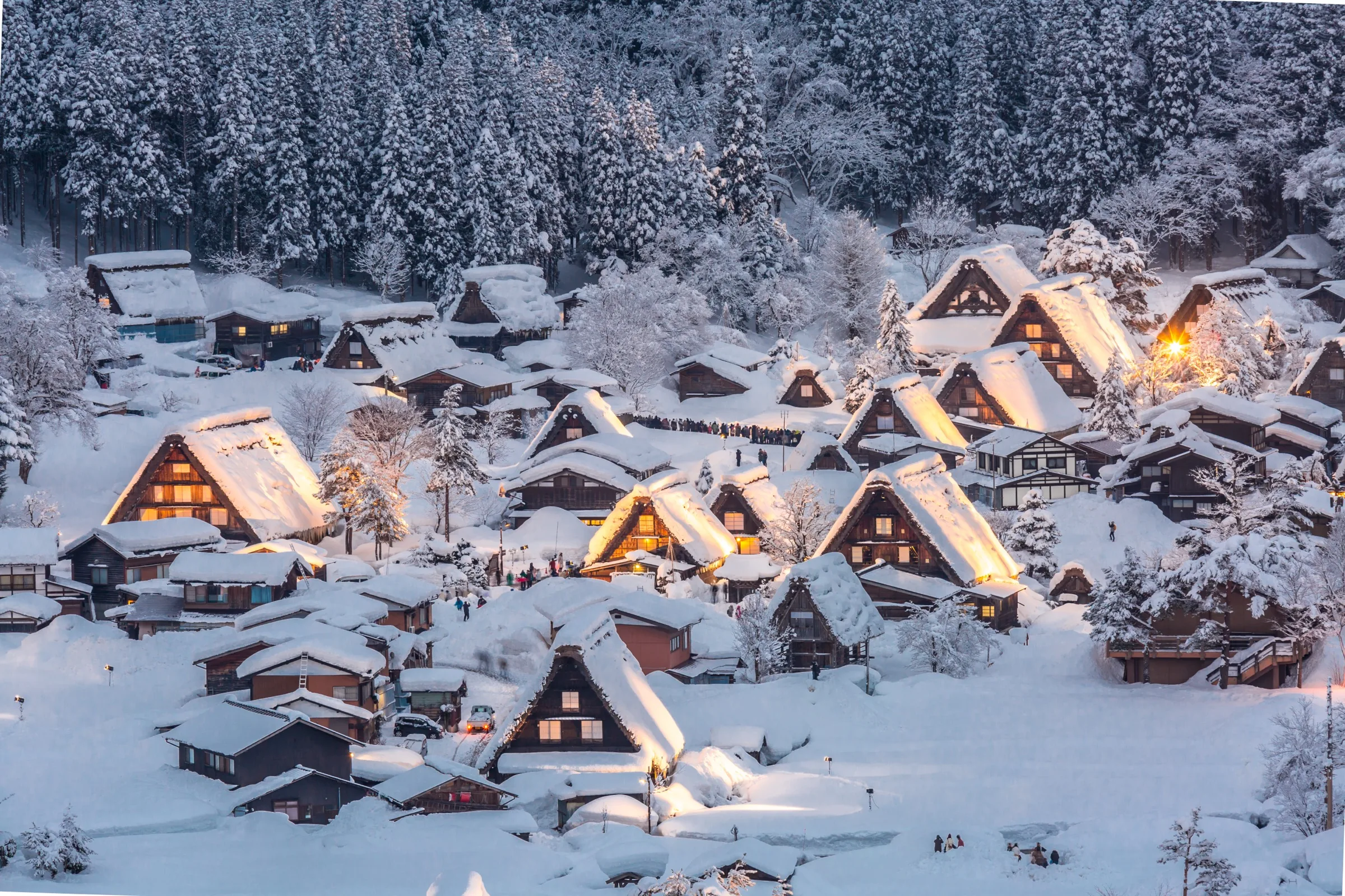 Shirakawa-go gassho-zukuri thatched-roof village illuminated at dusk under heavy winter snow