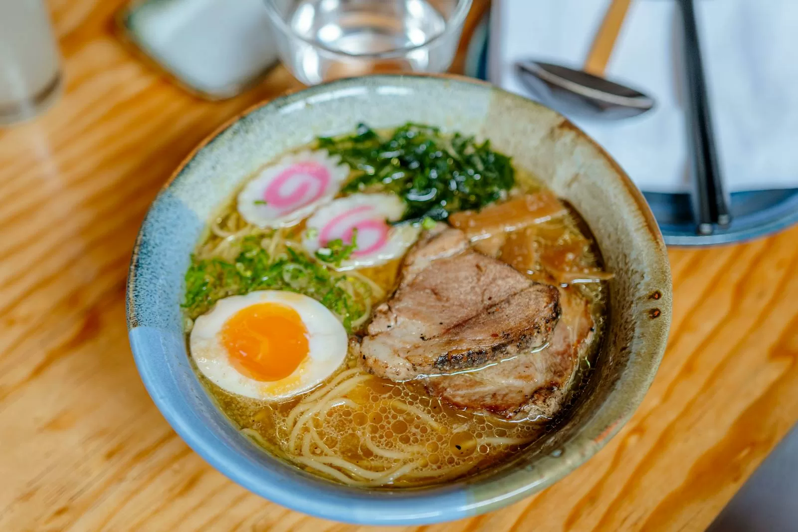 Bowl of ramen with pork, egg, and fresh toppings