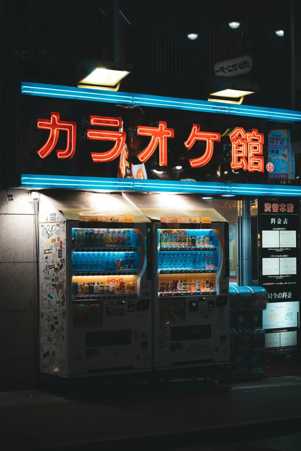Illuminated row of Japanese vending machines on a street at night