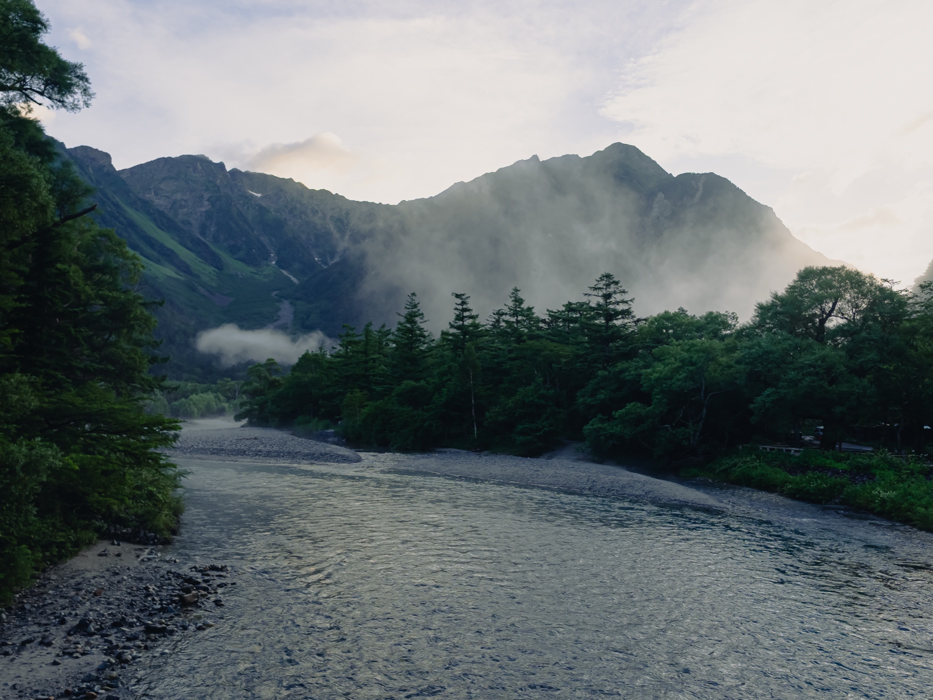 Azusa River at dawn with morning mist hovering over the water surface and Hotaka peaks partially hidden behind clouds