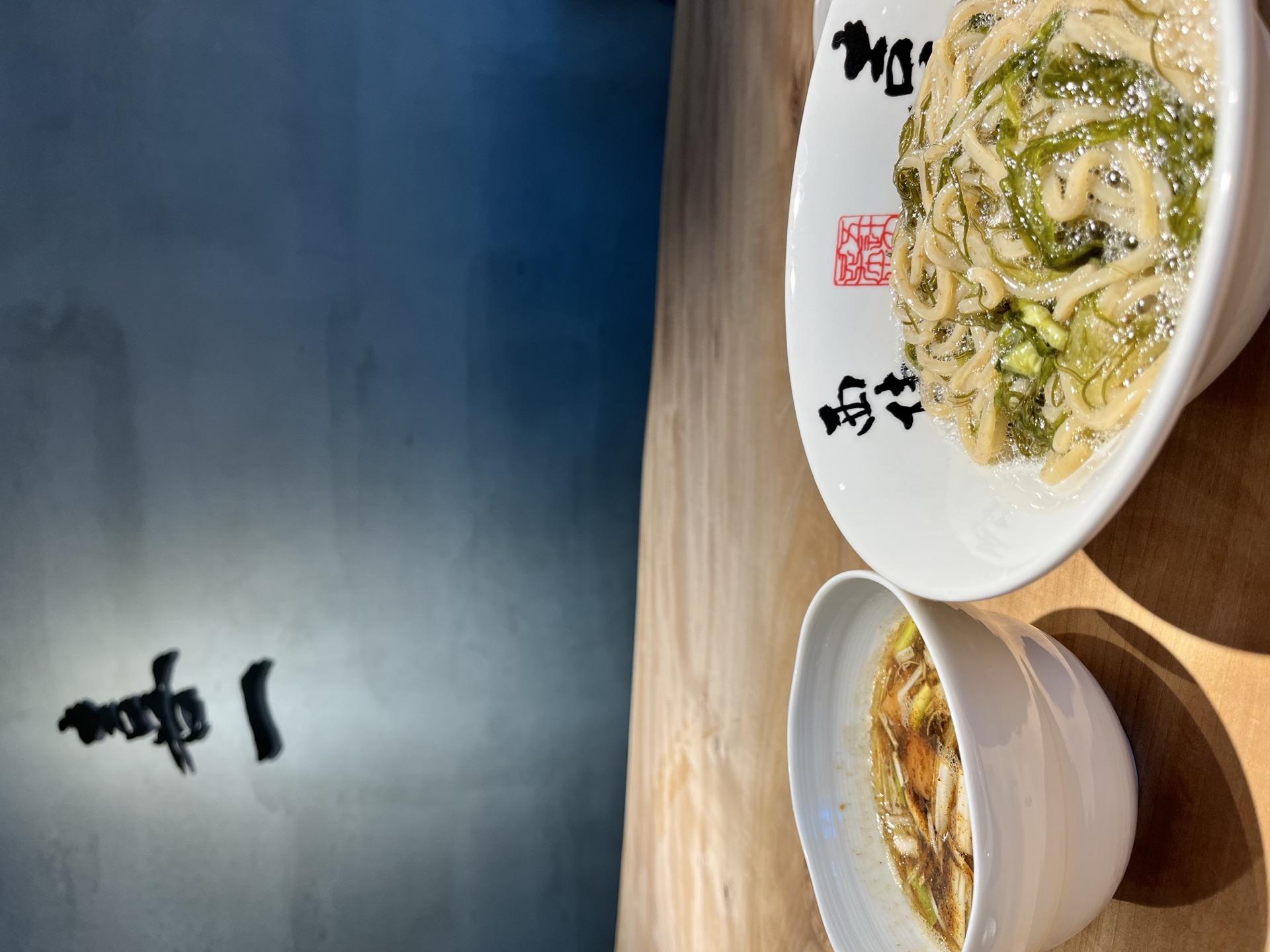 Kiichi ramen bowl with the open-sign wall in the background