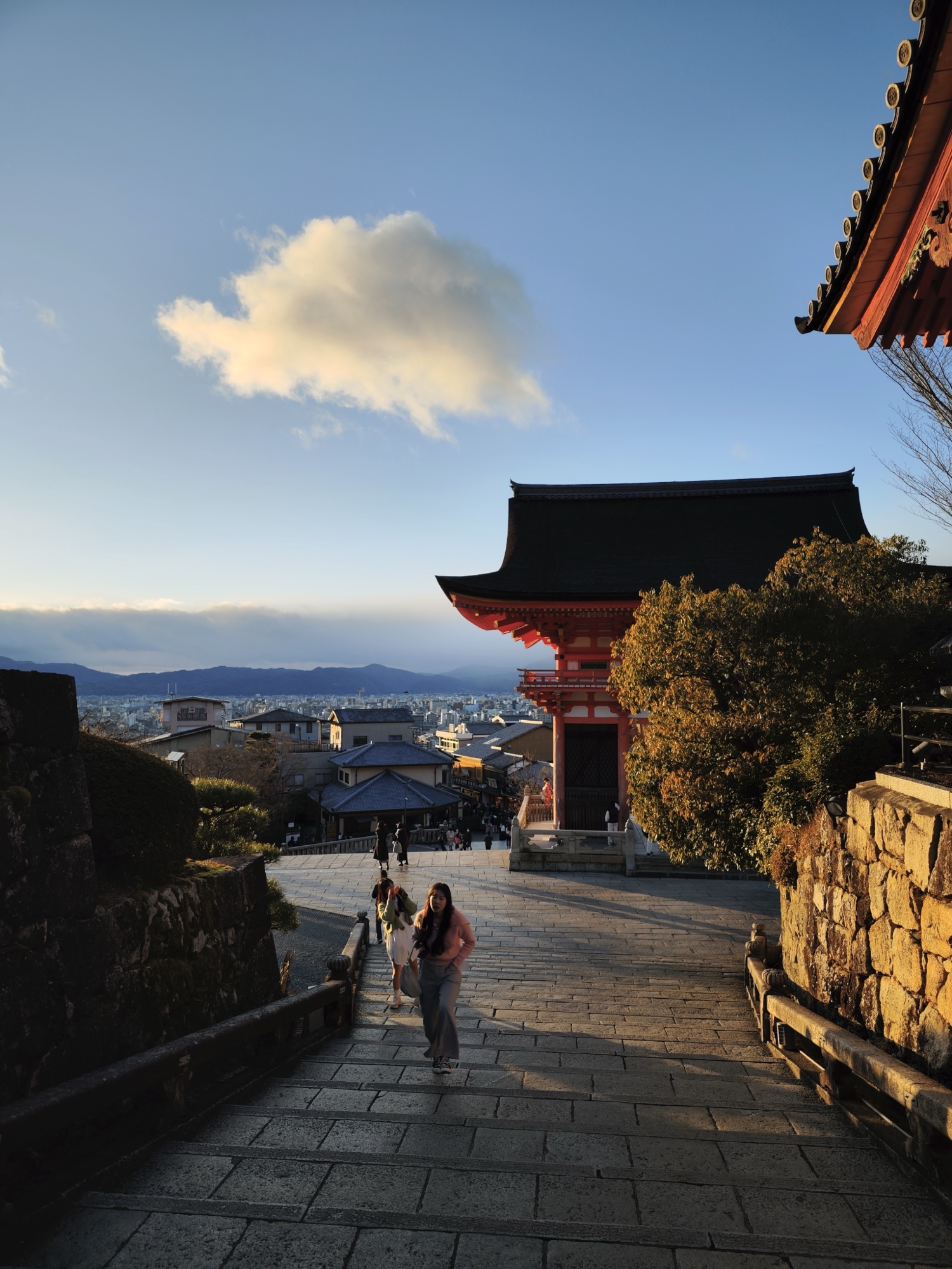 Nishi-mon West Gate of Kiyomizudera with distant Kyoto cityscape in golden hour