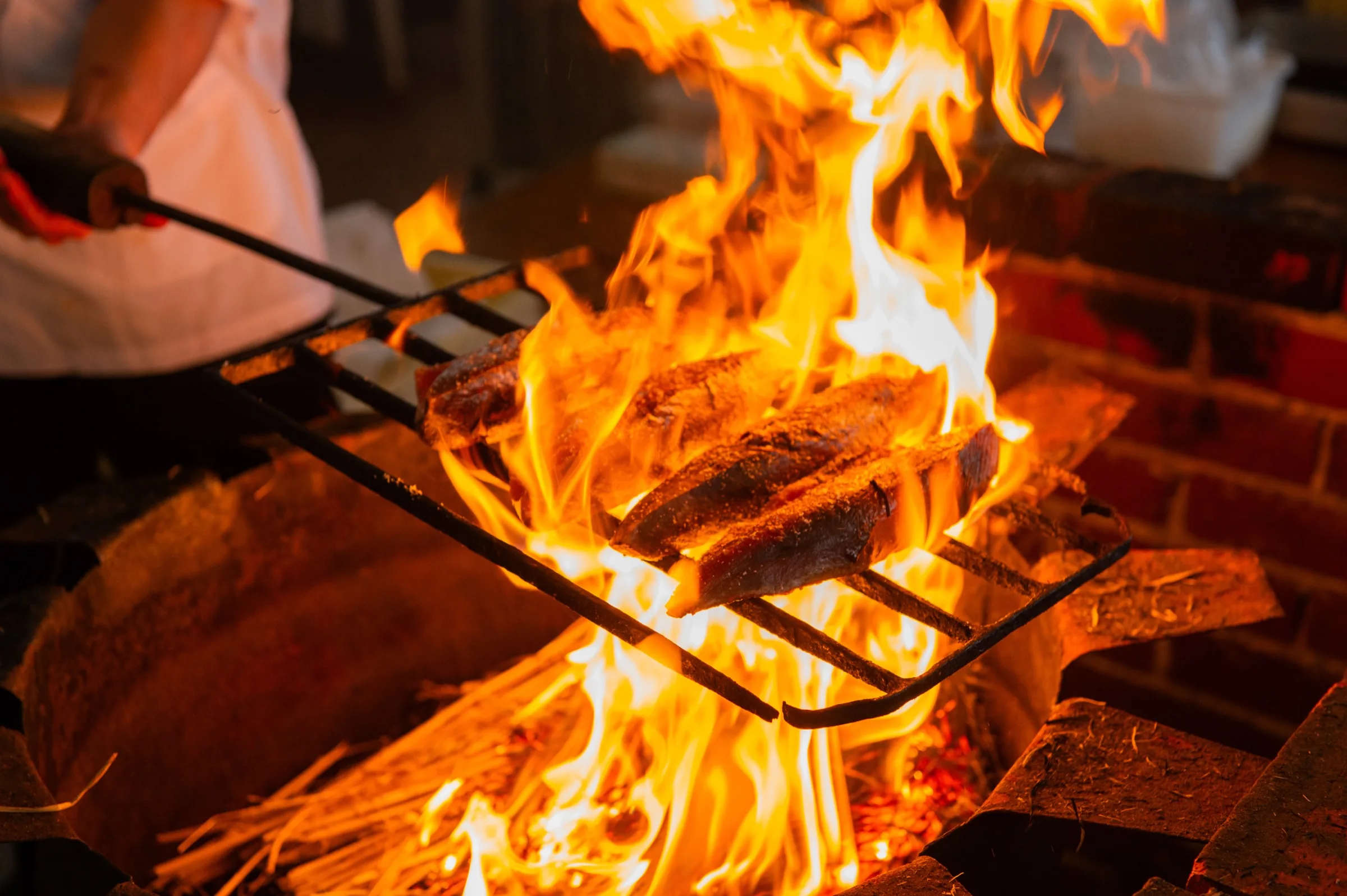 Katsuo bonito loins being seared over a straw fire to make tataki at a Kochi specialty stall