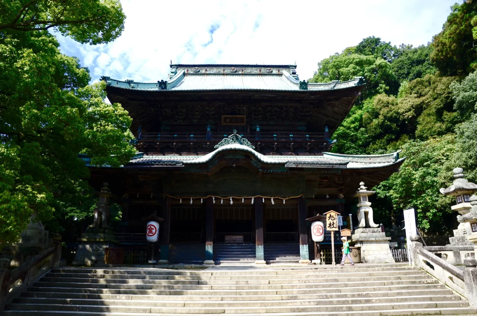 Asahi-no-Yashiro hall at Kotohira-gu with a copper roof and carved eaves among trees