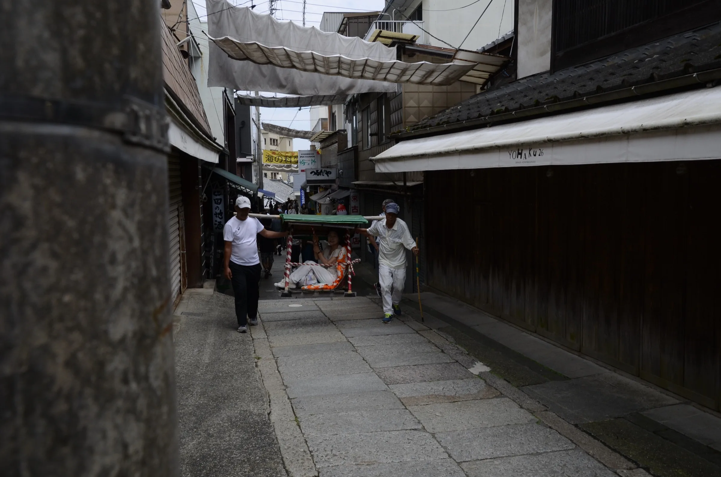 Two kago palanquin carriers transporting a visitor up the Konpira-san approach steps