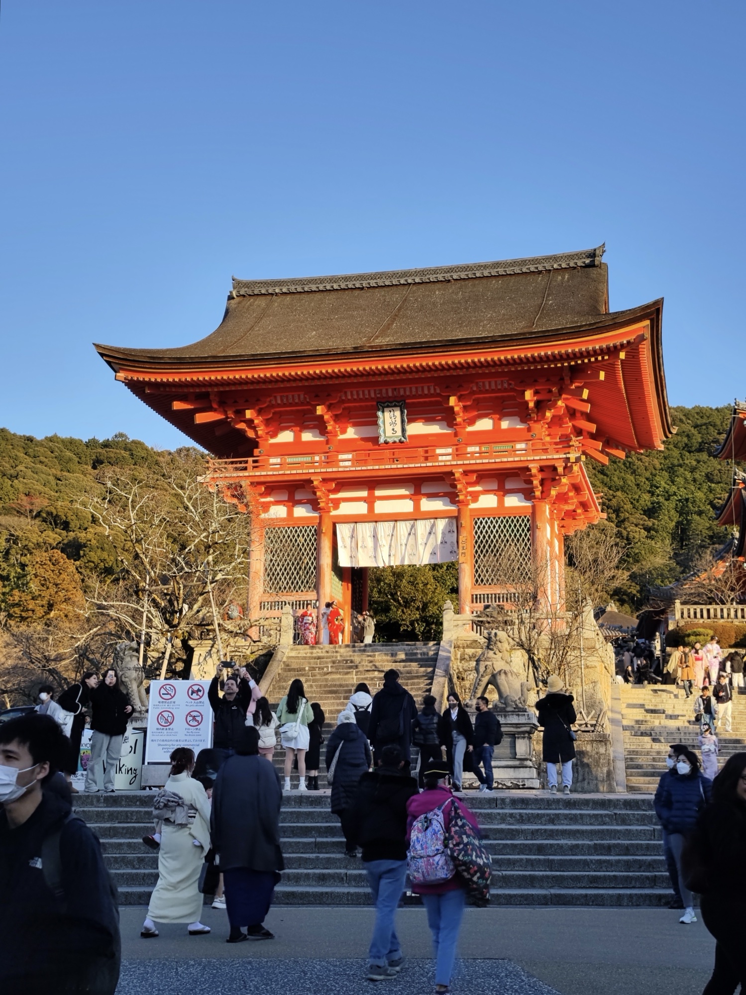 Vermilion Nio-mon Deva Gate of Kiyomizudera temple with stone steps and visitors at Kyoto UNESCO site