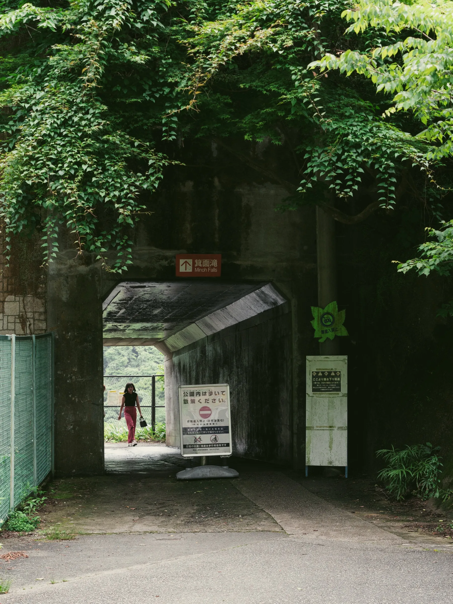 Stone tunnel under railway with the Minoo Falls trail (Takimichi) signpost